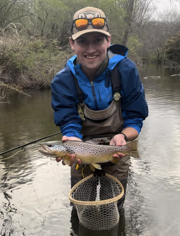 man in water holding trout